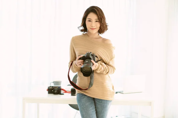Cheerful Asian Woman Photographer Standing Desk Working Professional Camera Looking — Stok fotoğraf