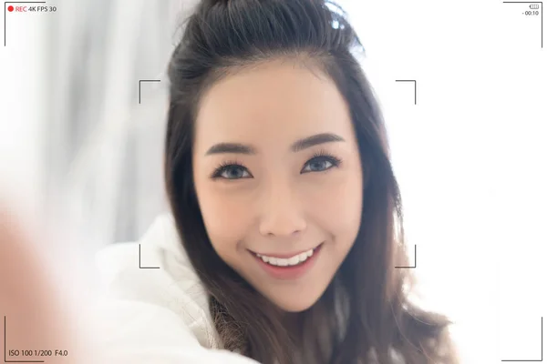 笑顔のアジア人女性の閉鎖はベッドに座っている間 カメラで手から自画撮り記録ビデオVlogを作ります 日本語または韓国語の女の子のカメラ画面は ソーシャルメディアアプリケーションで話してボルギング — ストック写真