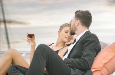 Yaz gününde romantik bir tatil ve lüks bir seyahat. Güzel bir çift, gün batımında yatta lüks bir yatta şarap içerek birbirlerini seviyorlar. İnsanlar tekne gezisinde evlilik yıldönümlerini kutluyor..