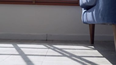 Çoraplı bir kadının akşamları kanepeden kalkıp evdeki oturma odasında yerde yürümesini. Gri ahşap zeminde beyaz çizgili çoraplar giyen ayaklar.
