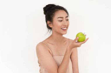 Beautiful young Asian woman holding and looking green apples to enjoy healthy food the taste good. Japanese girl healthy eating an organic fresh red apple. Vitamins and minerals, Dieting concept.
