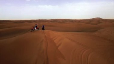Dubai Çölü 'nün hava panoramik manzarası, bisikletli kumul yarışçıları. Rub al Khali, Abu Dabi, UAE.4K, kamera görüntüleri.