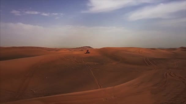 Aerial panoramic view of Dubai desert with lone racer on bike.Hes stand on dune in the Rub al Khali,Abu Dhabi,UAE. — Stock Video
