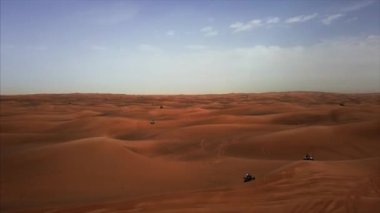 Bisiklet ve atletizm yarışçıları ile Dubai Çölü 'nün dikey hava manzarası. Rub al Khali, Abu Dabi, UAE.4K, görüntüler..