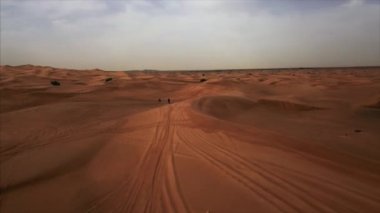Bisiklet ve atletizm yarışçıları ile Dubai Çölü 'nün dikey hava manzarası. Rub al Khali, Abu Dabi, UAE.4K, görüntüler..