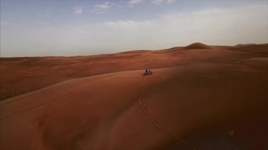 Bisikletli bir yarışçıyla Dubai Çölü 'nün havadan panoramik görüntüsü. Rub al Khali, Abu Dabi, BAE. 4K, görüntüler.