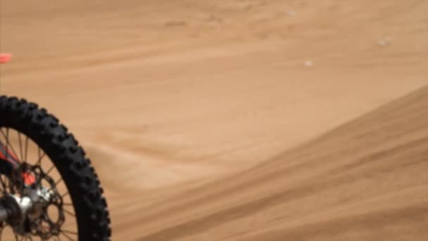 Slow motion close-up zicht op de motor rijden op zand duin en zweven in de lucht — Stockvideo