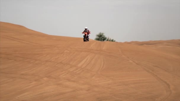 骑摩托车的人的慢镜头.从迪拜、阿联酋、阿布扎比的沙丘后面飞出。4k，录像 — 图库视频影像