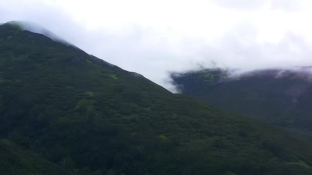 Kamchatka,ロシア8月27,2020:雲と霧霧の中で山のスローモーション空中パノラマ風景. 4k,映像 — ストック動画