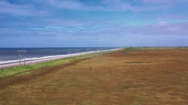Kamçatka, Rusya-Aug 27,2020: Sahil deniz okhotsk, yol, çayır ve tarlaların yavaş hareket eden hava manzarası. 4k, görüntüler