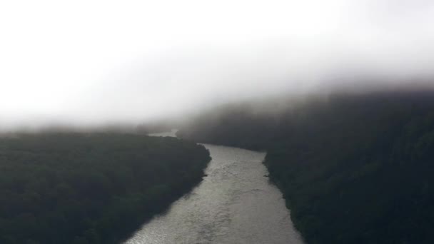 Ralenti vol vers le haut à travers les nuages avec paysage de rivière et de forêt. 4k — Video