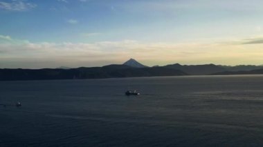 Deniz manzaralı bir gemi ve tepeli bir dağ kıyısı. Rusya