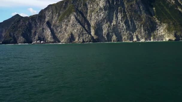 Paisaje marino aéreo de orcas y bote con roca de montaña. Kamchatka, Rusia — Vídeos de Stock