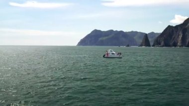 Dağlarla kıyıya yakın deniz manzaralı havadan panoramik tekne manzarası.