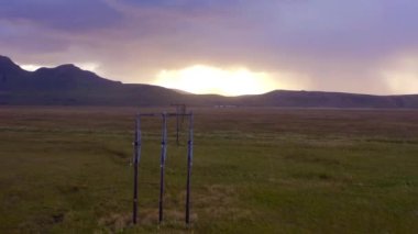 Günbatımı sahasının, dağ sırasının ve güç şebekesinin hava panoramik manzarası