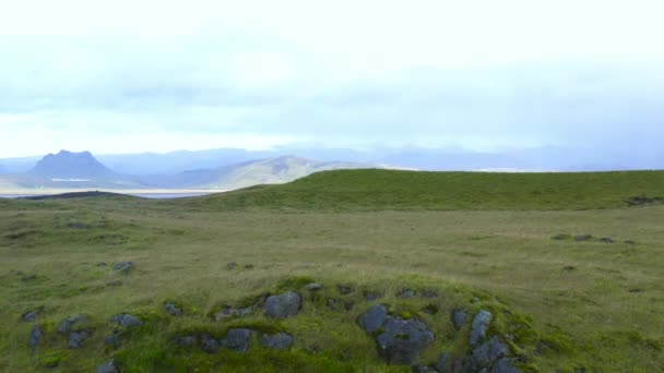 Luchtvlucht over heuvel met uitzicht op meer, andere heuvels en bergketen — Stockvideo