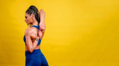 Spor yapan kız, sarı arka planda.