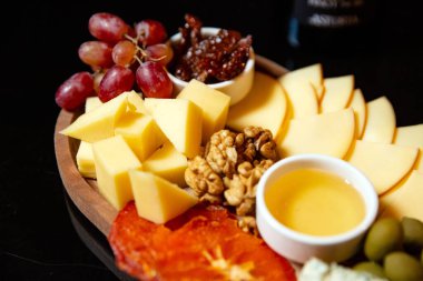 Siyah arka planda peynir tabağı. Yakın plan.