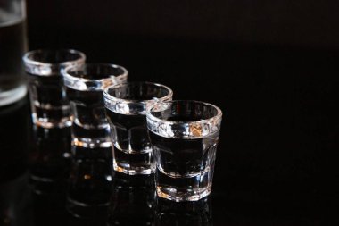 Siyah arka planda bir bardak votka.