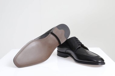 Beyaz arka planda siyah erkek ayakkabıları.