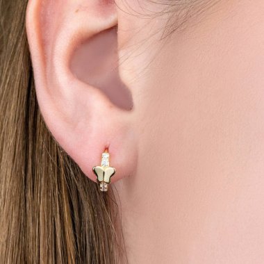 Genç, güzel esmer kadın modelin yakın portresi altın ve gümüş küpeler ve yüzük sunuyor. Beyaz arka planda izole edilmiş, resmi takım elbiseli bir kadının stüdyoda poz vermesi..