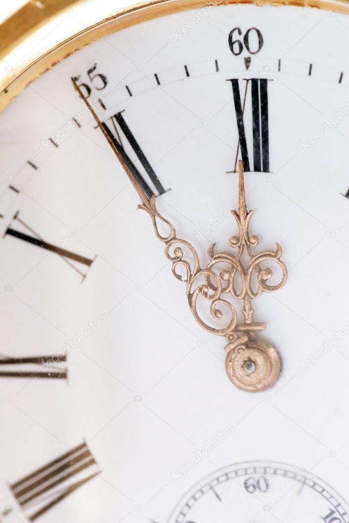 Pocket watch in a gold case on a white background, zoom