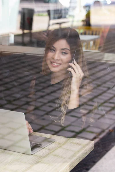Cep telefonuyla konuşan genç ve olumlu bir iş kadını, ofis dışında çalışan bir girişimci. İş konsepti