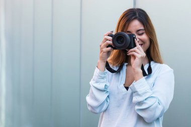 Profesyonel kamerayla fotoğraf çekerken gülümseyen fotoğrafçı, güzel esmer kadın. Metin için kopya alanı olan hobi kavramı, arkaplan
