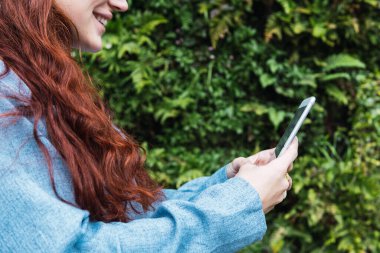 Akıllı telefonuna bakan genç ve güzel bir iş kadını. Cep telefonuna mesaj yazan bir kızın ellerinin kapatılması, mesaj için boş alan