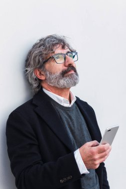 Senior businessman using mobile phone, typing message to partners after conference, discuss things on the agenda