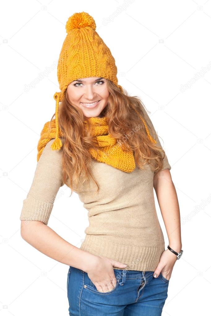 Portrait of the happy beautiful girl in a knitted cap on a white background