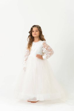 Altı yaşında güzel bir kız poz veriyor, kameraya bakıyor. Stüdyo portresi. Beyaz arkaplan