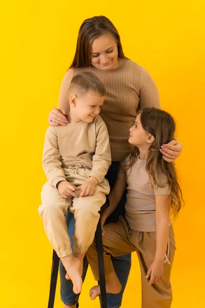 Eine junge Mutter mit ihren Kindern schaut einander an — Stockfoto