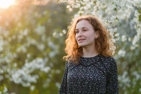 Gülümseyen, neşeli, güzel kızıl saçlı genç bir kadın fotokopi odasına bakıyor. Genç kızıl saçlı bir kadının portresi.