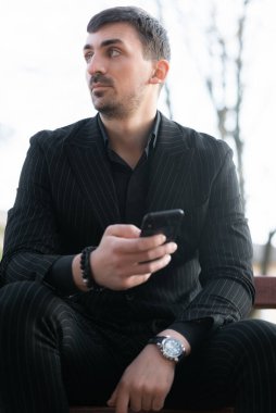 Genç bir işadamı telefonu kullanarak yeni bir iş arıyor. Yeni bir iş bulmak