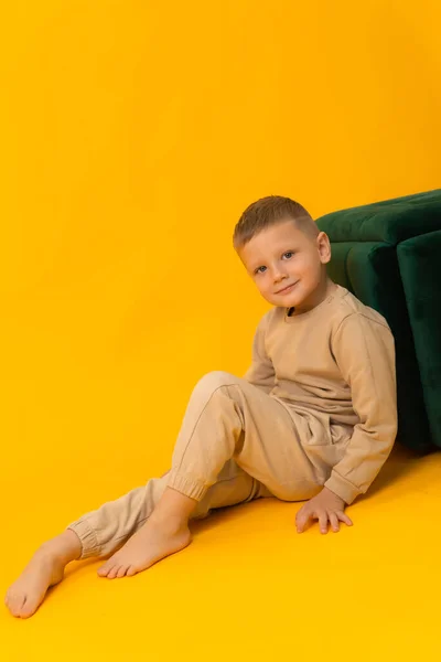Menino Atraente Terno Está Sentado Perto Uma Cadeira Verde Fundo — Fotografia de Stock