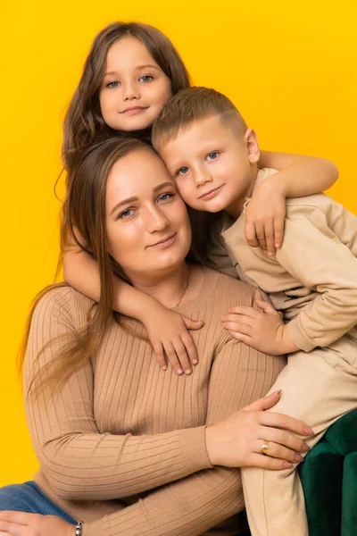 Fürsorgliche Mutter Mit Ihren Kindern Auf Gelbem Hintergrund Studioporträt — Stockfoto