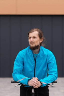 Genç bir adam işe bisikletle taşınıyor. Şehirde bisiklet sürmek