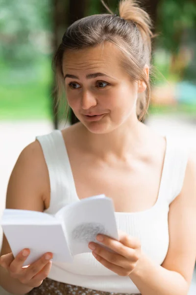 Una Joven Está Leyendo Libro Mirando Lado Con Sorpresa Mujer — Foto de Stock