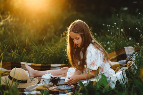Una Chica Está Poniendo Trozo Pastel Durante Picnic Jardín Atardecer — Foto de Stock