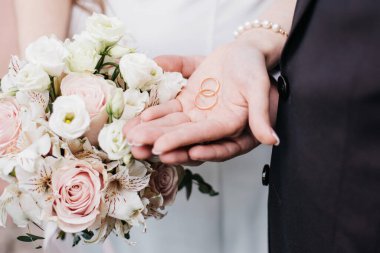 Ellerinde alyans tutan evli bir çift.