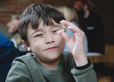 Çocuk portre çocuk yemek beklerken yemek çubuğu tutuyor. Çocuk Japon restoranında oturuyor.