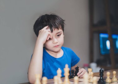 Concentrated Young boy developing chess strategy, playing board game with parent at home. Activity or Hobby for Family Concept 
