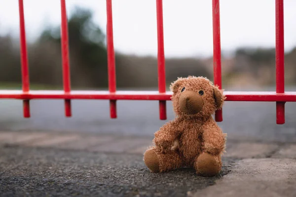 Juguete Oso Peluche Perdido Sentado Junto Una Valla Metal Patio —  Fotos de Stock