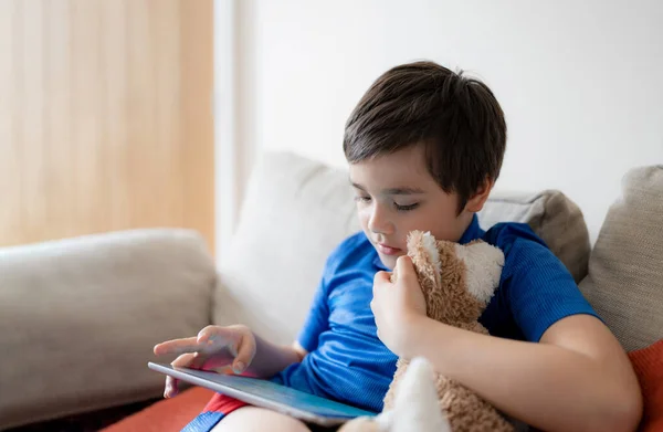 Potret Anak Laki Laki Bermain Game Pada Tablet Duduk Sofa — Stok Foto