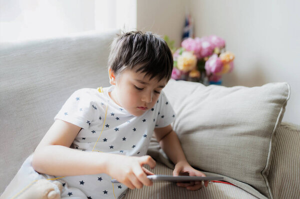 High Key Portrait Kid Playing Game Tablet Sitting Sofa Light Stock Image