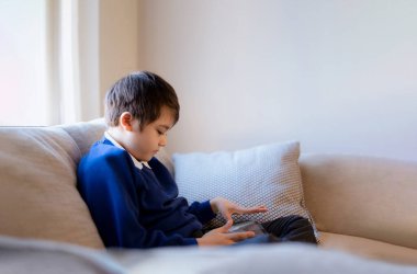 School boy using tablet doing school homework, Kid learning virtual internet online education, Child playing game with digital tablet at home, Cute boy using gadgets for learning