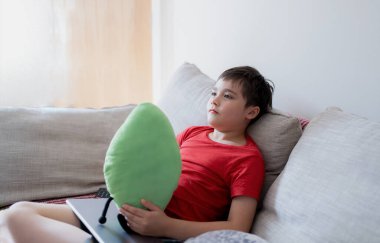 Portre Çocuk gülümseyen yüzüyle ve pelüş oyuncağıyla dışarı bakıyor, tatlı çocuk kanepede oturuyor ödevini bitirdikten sonra dinleniyor, Pozitif Çocuk kanepede tek başına televizyon izliyor.