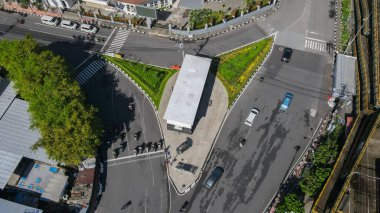 Birkaç araçla kavşakta, kavşağın ortasında bir bina var..