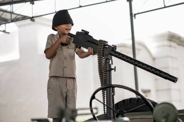 Küçük çocuk silahlarla oynuyor ve savaş tarihini öğreniyor. 1. : Yogyakarta, Endonezya - 01 Mart 2022
